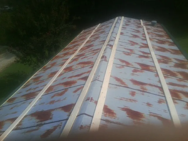 Rusted metal roof panels with new wood purlins before replacement — Storm Damage Roof Repair in Lowgap by Roofing Brothers