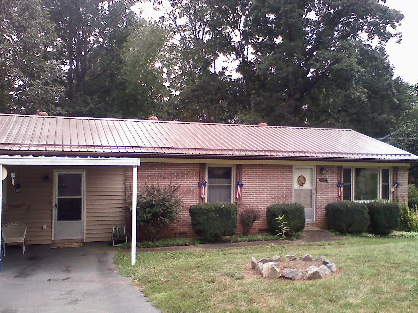 Bronze metal roof and carport on a brick ranch home — Roof Repair work by our crew in Lowgap